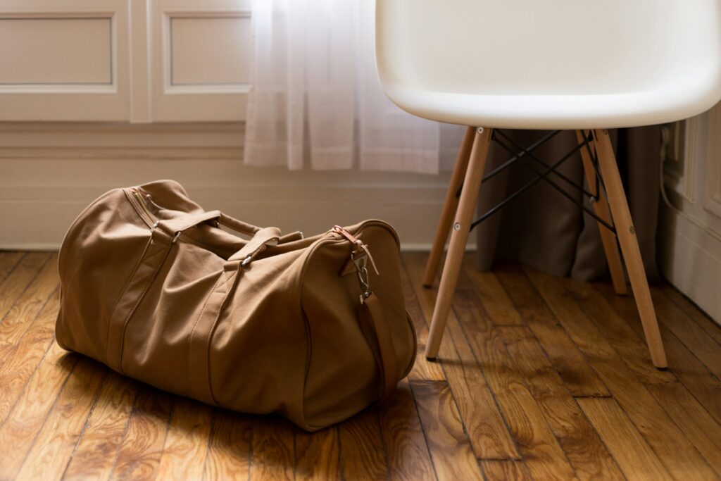 A leather and canvas sand-colored duffel bag